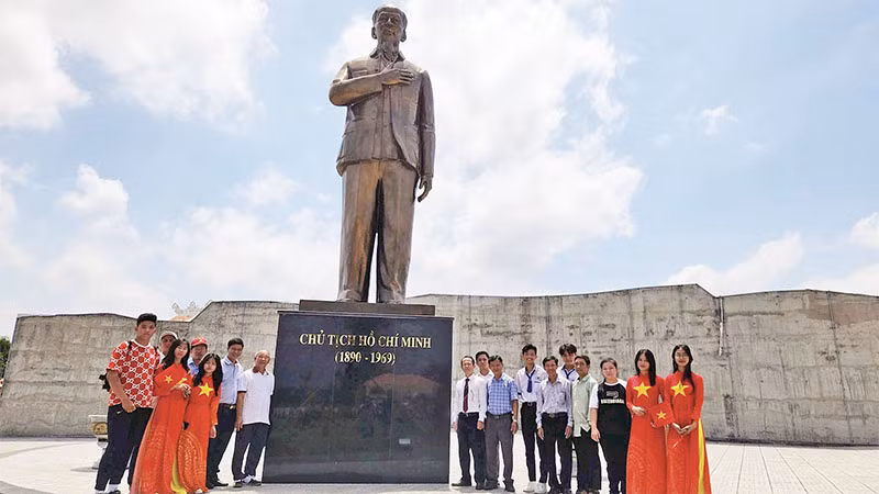 Thầy và trò Trường THCS và THPT Mong Thọ chụp ảnh dưới bức tượng Chủ tịch Hồ Chí Minh tại Khu chứng tích chiến tranh rừng tràm Bang Biện Phú.
