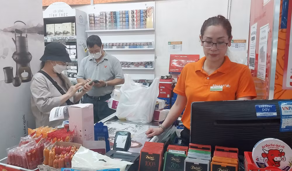 Người dân thanh toán hóa đơn mua hàng qua smart phone tại siêu thị BRGmart, quận Hoàn Kiếm, Hà Nội. 