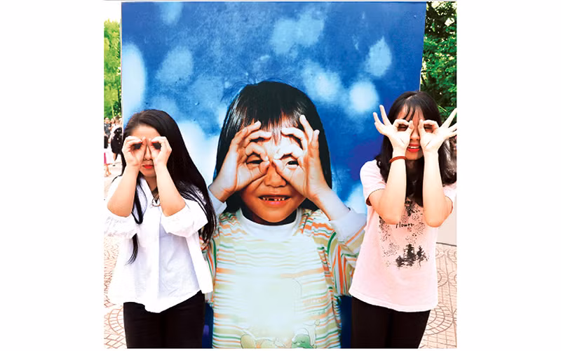 Hào hứng tạo dáng tại triển lãm "Thắp sáng nụ cười Việt Nam". Ảnh: THÀNH ĐẠT