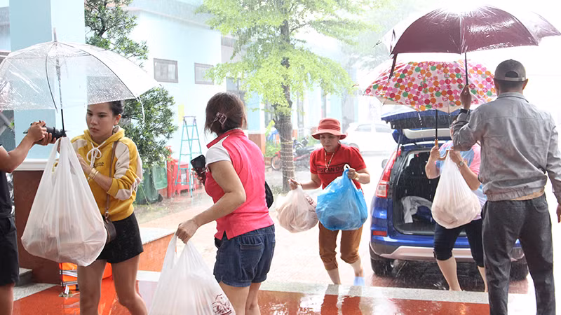 Cán bộ phường nhận bánh mì để phát cho các hộ dân.