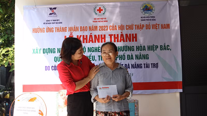 Bà Nguyễn Thị Đạt bên ngôi nhà mới hoàn thành.
