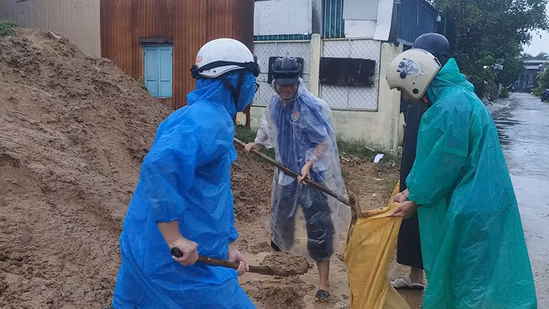 Hỗ trợ người dân chuẩn bị các bao cát để chằng mái nhà. Hỗ trợ người dân chuẩn bị các bao cát để chằng mái nhà.