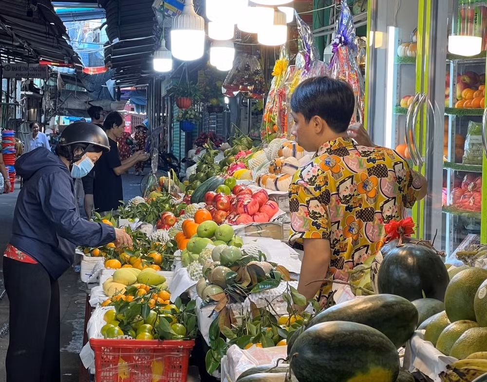 Người dân chọn mua trái cây tại chợ Tân Định, quận 1, Thành phố Hồ Chí Minh, sáng mùng 4 Tết. (Ảnh: Hoàng Liêm)