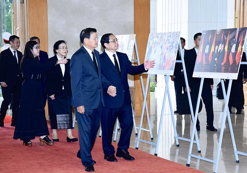 Thủ tướng Phạm Minh Chính giới thiệu với Tổng Bí thư, Chủ tịch nước Lào Thongloun Sisoulith một số hình ảnh về hoạt động đối ngoại của Tổng Bí thư Nguyễn Phú Trọng.