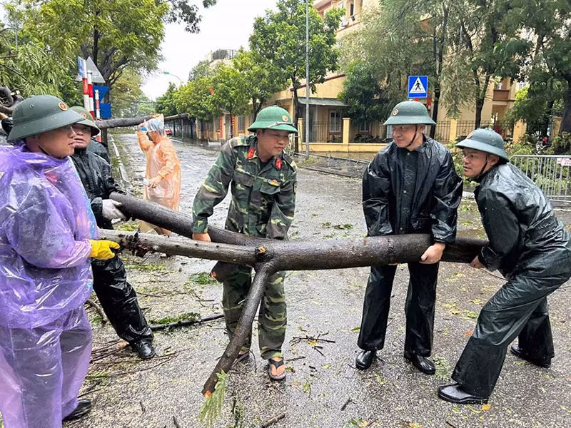 Các đơn vị quận Hoàng Mai thu dọn cây xanh bị gãy đổ trên đường phố.