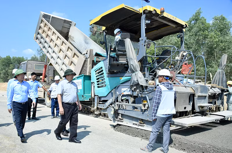 Thủ tướng Phạm Minh Chính hỏi thăm một công nhân đang thi công trải nền đường Dự án đường bộ cao tốc Vân Phong-Nha Trang.