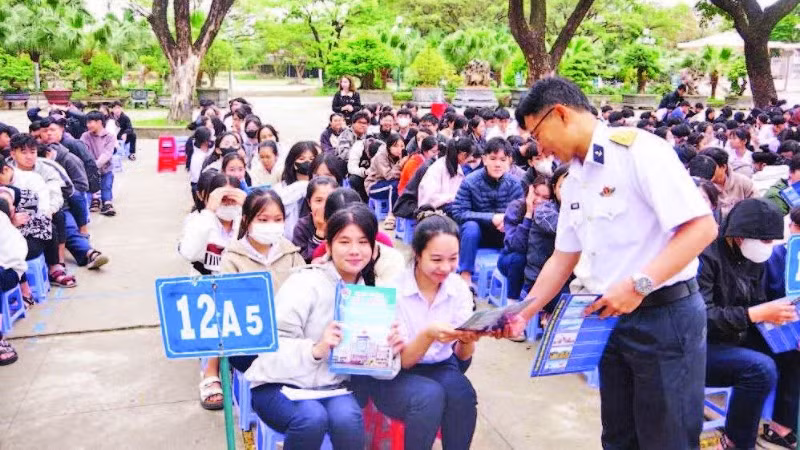 Báo cáo viên tuyên truyền, phát tờ rơi về thu hút nguồn nhân lực tại Trường THPT Hùng Vương, thành phố Quy Nhơn. (Ảnh THANH SANG)