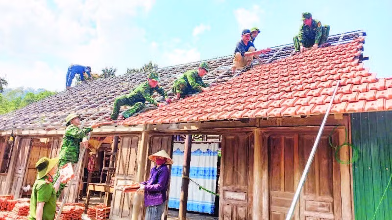 Đoàn viên Bộ đội Biên phòng và Công an tỉnh Quảng Bình tham gia sửa chữa nhà tạm cho hộ nghèo ở xã Thượng Hóa, huyện Minh Hóa.