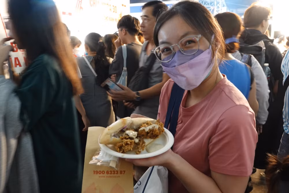 Một bạn trẻ vui mừng khi mua được ổ bánh mì cua.