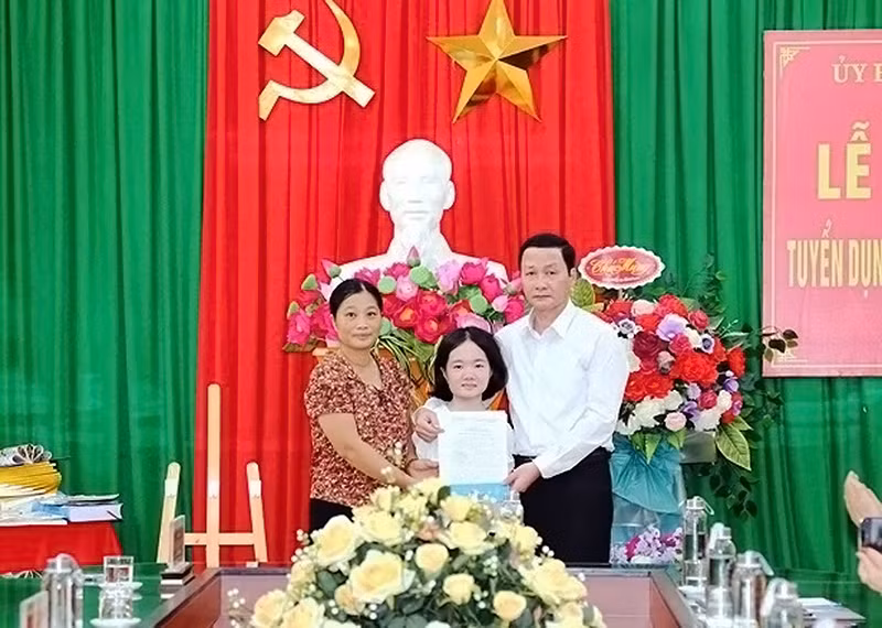 Chủ tịch Ủy ban nhân dân Tỉnh Thanh Hóa Đỗ Minh Tuấn (bên phải) trao quyết định tuyển dụng đặc cách cô Lê Thị Thắm làm giáo viên.