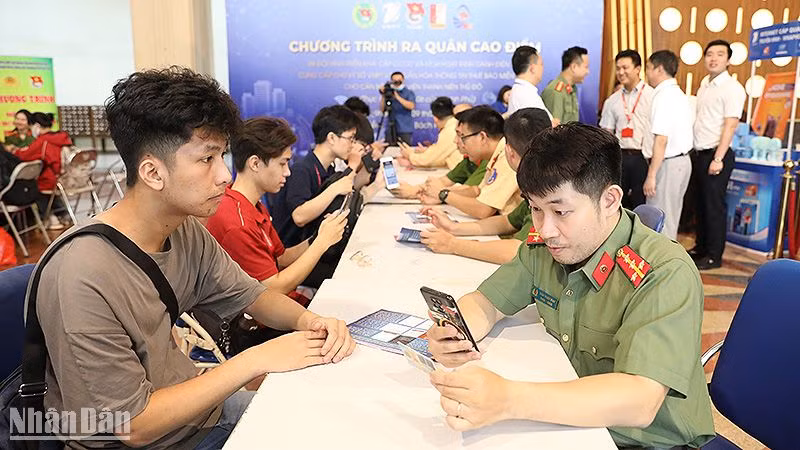 Chiến sĩ trẻ lực lượng công an thành phố Hà Nội hỗ trợ người dân kích hoạt định danh điện tử tại chương trình ra quân.