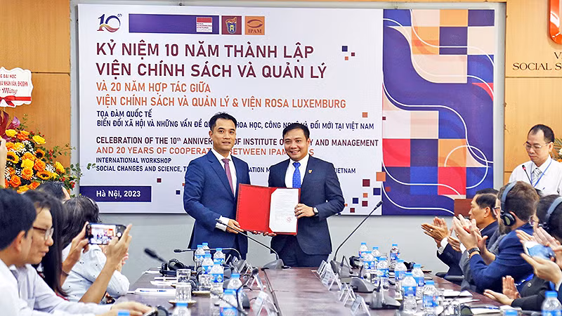 Phó Giám đốc Đại học Quốc gia Hà Nội Phạm Bảo Sơn (bên trái) trao quyết định công nhận Viện Chính sách và Quản lý là trung tâm nghiên cứu trọng điểm định hướng nghiên cứu ứng dụng giai đoạn 2023-2028. 