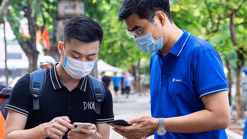 Đoàn viên VNPT hỗ trợ người dân cài đặt ứng dụng chuyển đổi số.