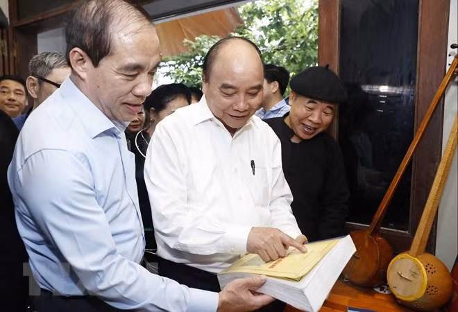 Chủ tịch nước Nguyễn Xuân Phúc thăm Nghệ nhân Ưu tú Ma Văn Đức ở phường Tân Hà, thành phố Tuyên Quang. (Ảnh: TTXVN)