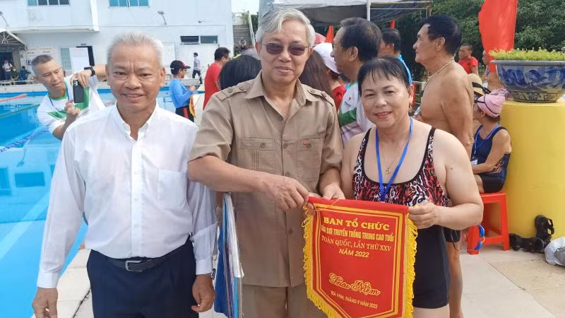 Phó Vụ trưởng Vụ Thể dục, thể thao quần chúng Phạm Đông Anh trao cờ lưu niệm cho đại diện đơn vị tham dự Giải bơi trung, cao tuổi.