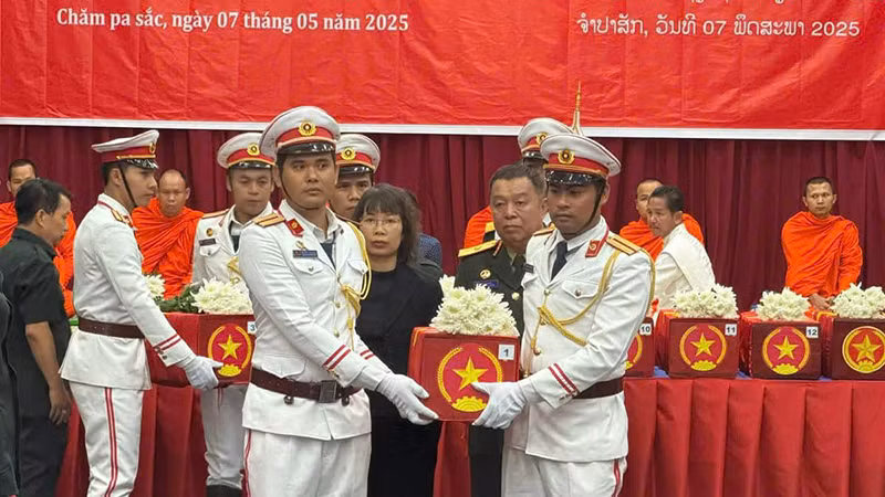 Các đại biểu thực hiện nghi lễ tiễn đưa hài cốt các liệt sĩ về nước. (Ảnh: HẢI TIẾN)