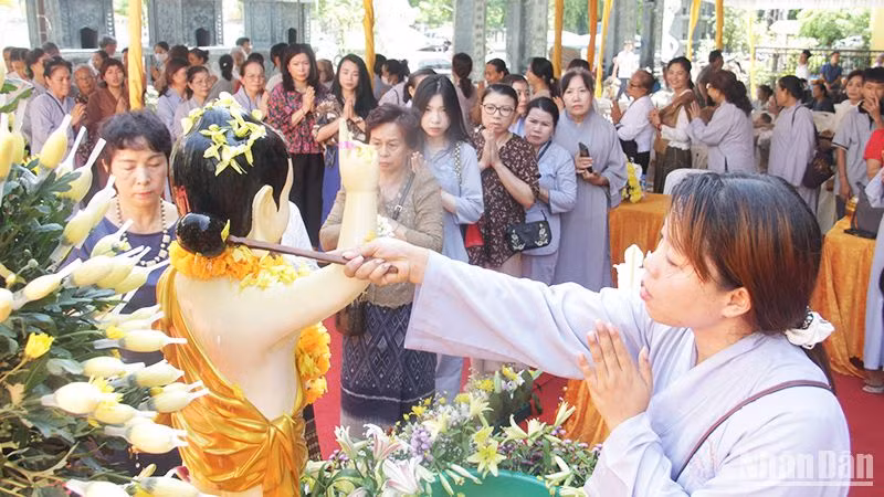 Chư Tăng, Phật tử và bà con kiều bào thực hiện các nghi lễ Tắc Bạt và tắm Phật. (Ảnh: HẢI TIẾN)