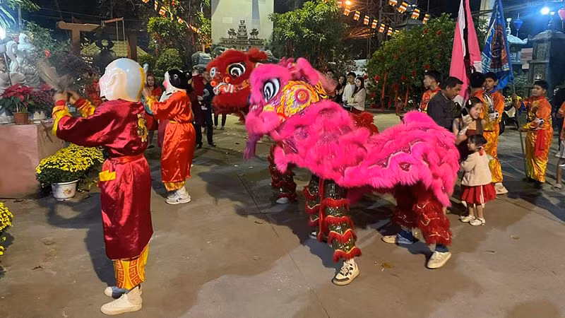 Đội múa lân chùa Phật Tích phục vụ bà con người Việt trong đêm Giao thừa. (Ảnh: Hải Tiến)