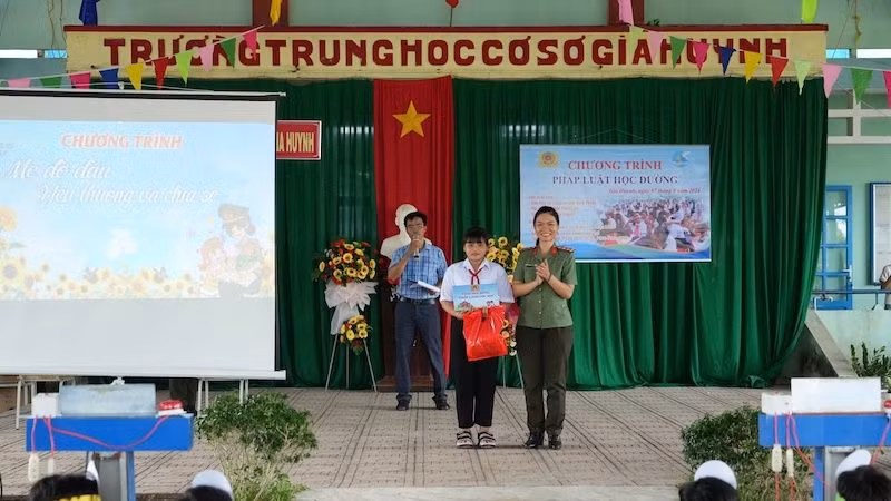 Đại úy Nguyễn Tú Trâm cán bộ đại diện Ban Phụ nữ Công an tỉnh trao quà và học bổng cho con đỡ đầu.