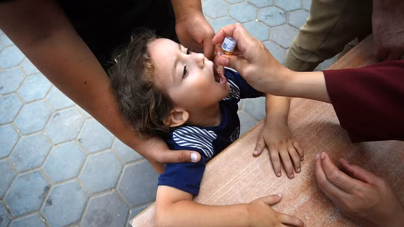 Một nhân viên y tế cho trẻ em Palestine uống vaccine bại liệt ở Deir Al-Balah, miền trung Gaza. (Ảnh UNRWA)