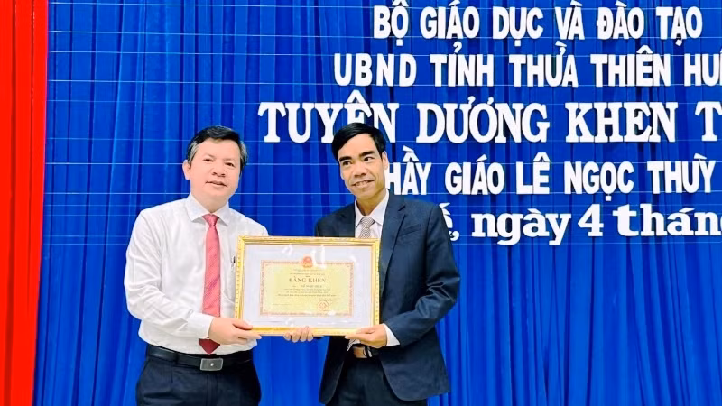 Giám đốc Sở Giáo dục và Đào tạo trao Bằng khen của Bộ Giáo dục và Đào tạo và UBND tỉnh cho thầy giáo Lê Ngọc Thùy (bên phải).