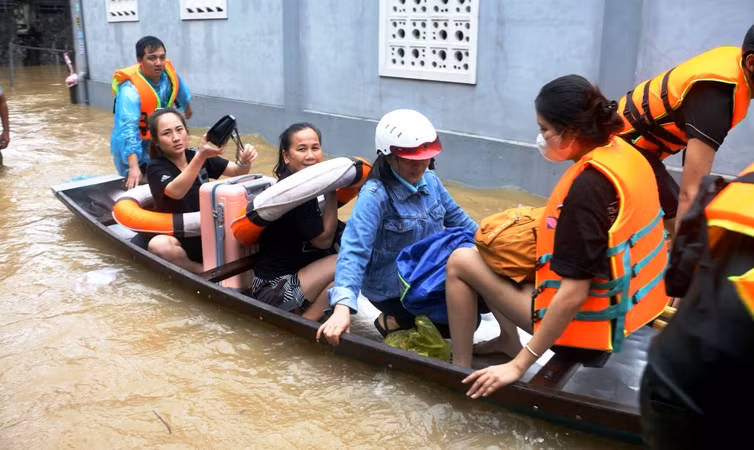 Các lực lượng chức năng di dời người già, trẻ em và sinh viên nữ tại khu vực ngập sâu ở xóm Gióng, phường An Tây (thành phố Huế).