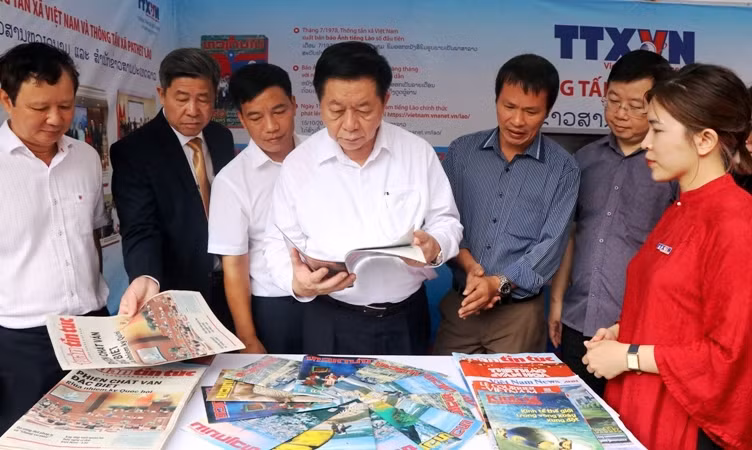 Đồng chí Nguyễn Trọng Nghĩa cùng lãnh đạo các ban, ngành và tỉnh Thừa Thiên Huế thăm gian hàng ấn phẩm thông tin, chương trình truyền thông bằng tiếng Lào của Thông tấn xã Việt Nam.
