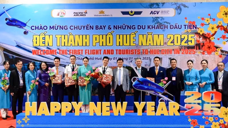 Lãnh đạo thành phố Huế và ngành du lịch chụp ảnh cùng nhóm hành khách đầu tiên cùng cơ trưởng và tiếp viên trưởng của chuyến bay.