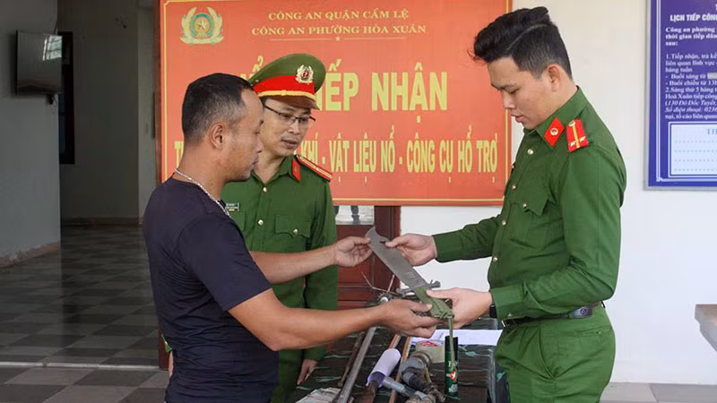 Người dân đến giao nộp vũ khí thô sơ cho Công an phường Hòa Xuân, quận Cẩm Lệ, thành phố Đà Nẵng. (Ảnh ĐINH NGA)