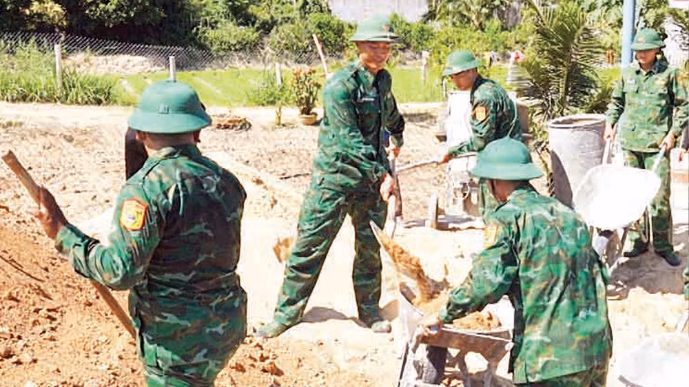 Cán bộ, chiến sĩ Đồn Biên phòng Cát Khánh tham gia xây dựng nhà cho chị Lê Thị Mười ở thôn An Nhuệ, xã Cát Khánh, huyện Phù Cát (Bình Định). 