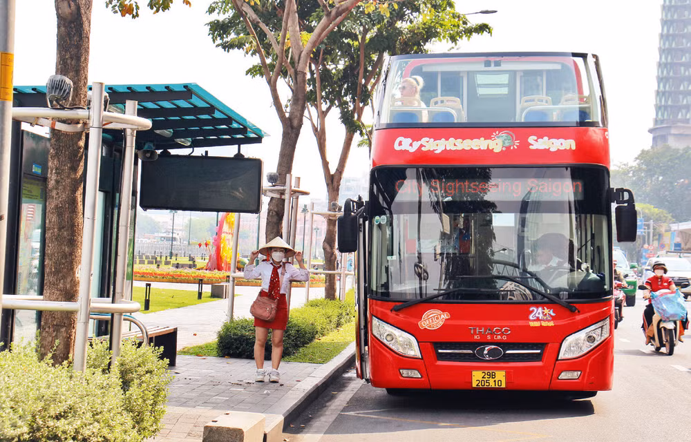 Người dân đón xe buýt tại trạm Bến Bạch Đằng, đường Tôn Đức Thắng, Quận 1. (Ảnh THẾ ANH) 