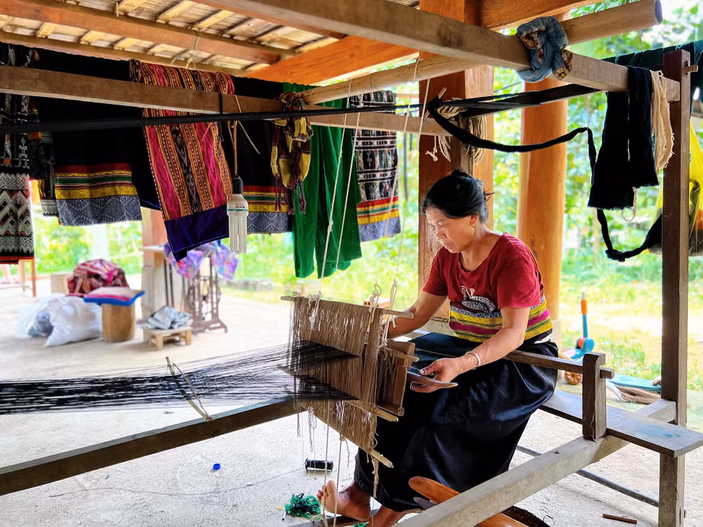 Công việc hằng ngày của bà Vi Thị Doanh (bản Ngàm, xã Sơn Điện) là dệt vải thổ cẩm và phục vụ khách tham quan. 