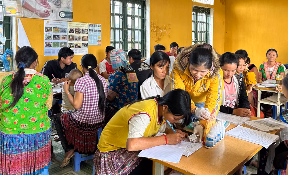 Giảng viên hướng dẫn học viên lớp đào tạo nghề tại bản Hua Huổi Luông cách ghi chép lịch tiêm phòng bệnh cho vật nuôi.