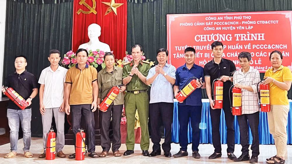 Cán bộ Phòng Cảnh sát Phòng cháy, chữa cháy và Cứu nạn, cứu hộ tặng bình chữa cháy cho người dân.