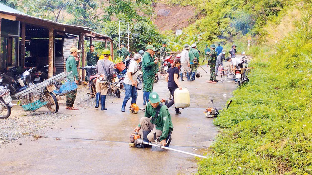 Cán bộ, chiến sĩ Đồn Biên phòng Ia Dom cùng người dân phát quang bụi rậm khu vực đường biên, cột mốc. 