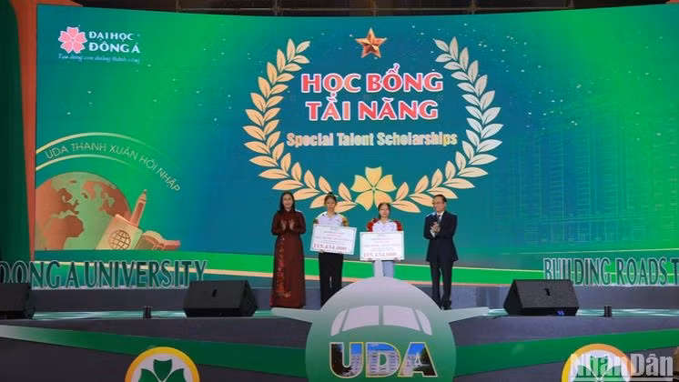 Phó Chủ tịch Ủy ban nhân dân thành phố Đà Nẵng Nguyễn Thị Anh Thi và ông Lương Minh Sâm, Chủ tịch Hội đồng trường Đại học Đông Á trao học bổng cho các sinh viên. Ảnh: ANH ĐÀO