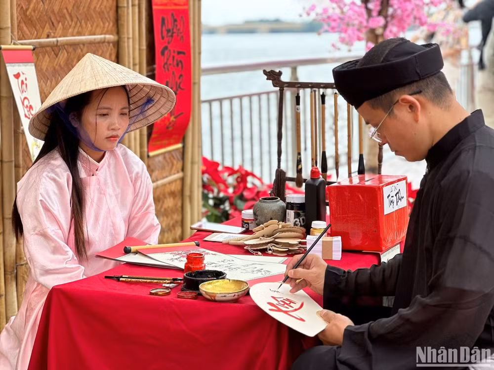 Du xuân Đà Nẵng và viết thư pháp bên bờ sông Hàn. (Ảnh: ANH ĐÀO)
