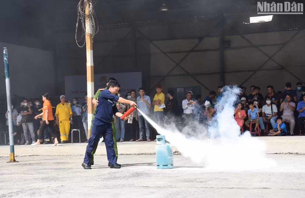 Người dân thực hành sử dụng bình chữa cháy dập lửa. Ảnh ANH ĐÀO Người dân thực hành sử dụng bình chữa cháy dập lửa. Ảnh ANH ĐÀO