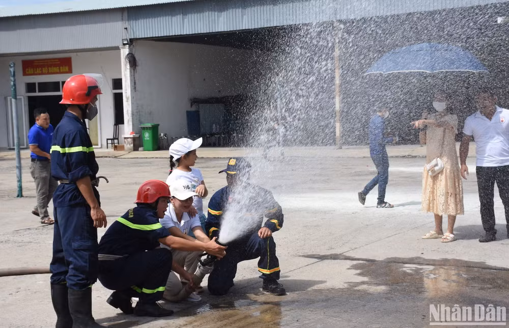 Người dân sử dụng kỹ năng sử dụng vòi phun nước dập lửa. Ảnh ANH ĐÀO Người dân sử dụng kỹ năng sử dụng vòi phun nước dập lửa. Ảnh ANH ĐÀO