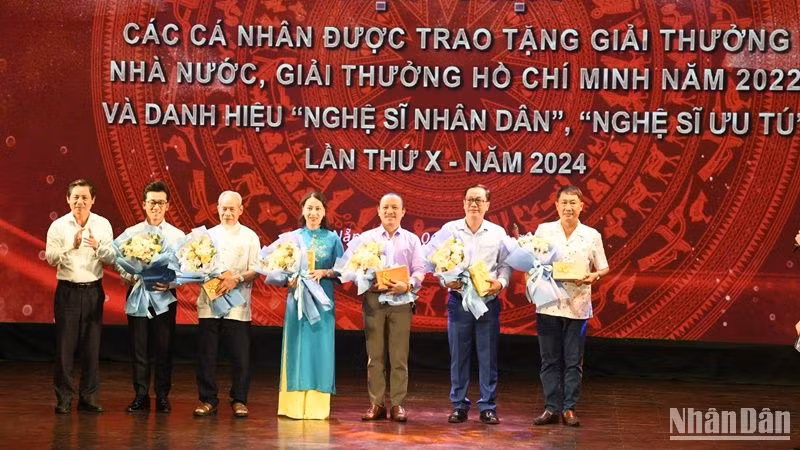Ông Phạm Tấn Xử, Giám đốc Sở Văn hóa và Thể thao thành phố Đà Nẵng tặng hoa chúc mừng các nghệ sỹ được phong tặng danh hiệu Nghệ sỹ ưu tú. (Ảnh: ANH ĐÀO)