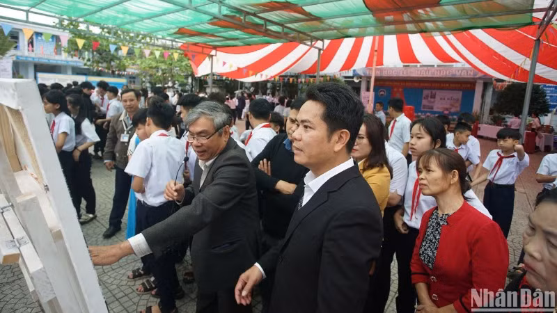 Nghệ sĩ nhiếp ảnh Ông Văn Sinh giới thiệu các tác phẩm của mình với học sinh và người dân xã Hòa Bắc, huyện Hòa Vang, thành phố Đà Nẵng. (Ảnh: ANH ĐÀO)