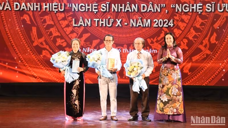 Phó Chủ tịch Ủy ban nhân dân thành phố Đà Nẵng Nguyễn Thị Anh Thi tặng hoa chúc mừng các cá nhân được phong tặng danh hiệu Nghệ sĩ nhân dân. (Ảnh: ANH ĐÀO)