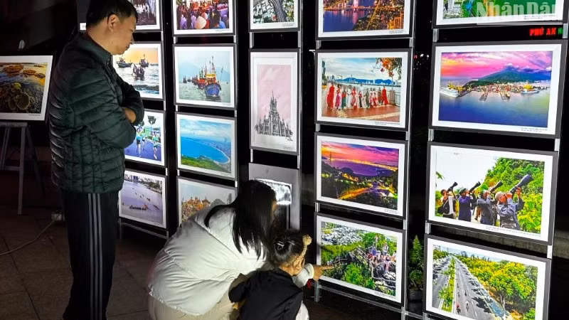 Người dân tham quan triển lãm mỹ thuật “Hành trình Phố Biển” tại Công viên APEC tối ngày 20/12. (Ảnh: ANH ĐÀO)