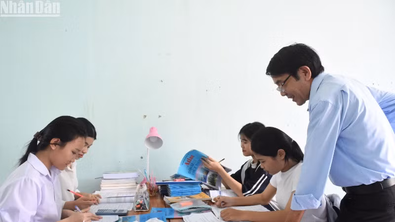Thầy giáo Võ Trinh, Hiệu trưởng Trường trung học phổ thông Phạm Phú Thứ (xã Hòa Sơn, huyện Hòa Vang, thành phố Đà Nẵng) thăm hỏi, động viên các em học sinh lớp 12 là con em đồng bào dân tộc Cơ Tu tại khu vực nội trú của trường, dự thi Kỳ thi tốt nghiệp THPT năm 2024. (Ảnh: ANH ĐÀO)