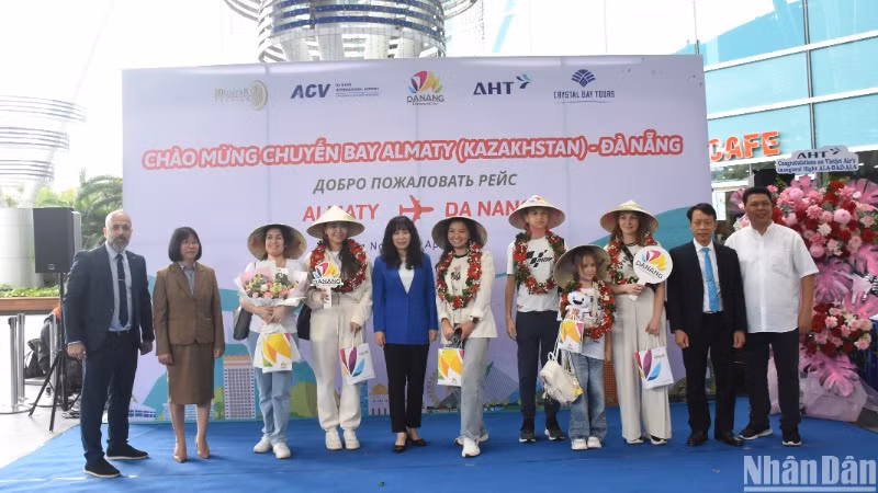 Những hành khách may mắn đầu tiên trên chuyến bay A330/300 đón nhận những phần quà ý nghĩa từ Sở Du lịch Đà Nẵng và các đơn vị liên quan. (Ảnh: ANH ĐÀO)