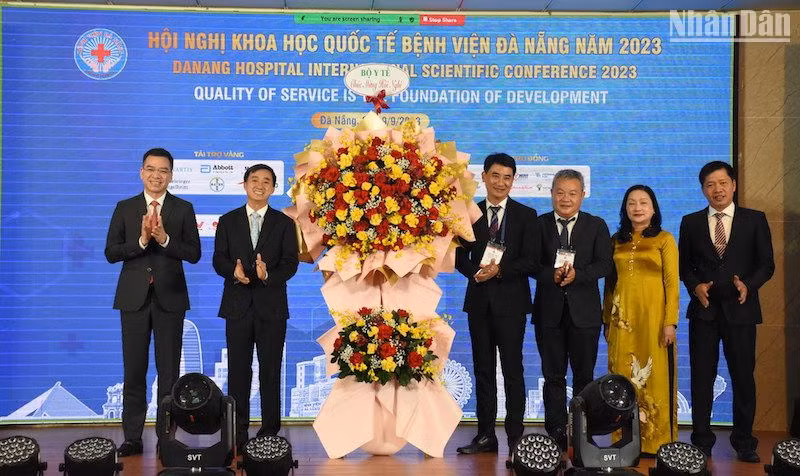 Thứ trưởng Y tế Trần Văn Thuấn tặng hoa chúc mừng Ban Giám đốc Bệnh viện Đà Nẵng. (Ảnh: ANH ĐÀO)