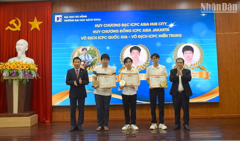 Phó Giáo sư, Tiến sĩ Lê Thành Bắc, Phó Giám đốc Đại học Đà Nẵng và Phó Giáo sư, Tiến sĩ Nguyễn Hữu Hiếu, Hiệu trưởng trường Đại học Bách khoa trao Giấy khen vinh danh các sinh viên xuất sắc. (Ảnh ANH ĐÀO)