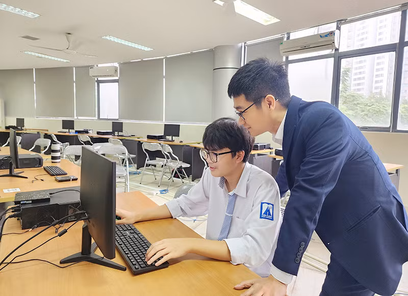 Học sinh Lê Trọng Khôi và thầy giáo trong giờ Tin học.