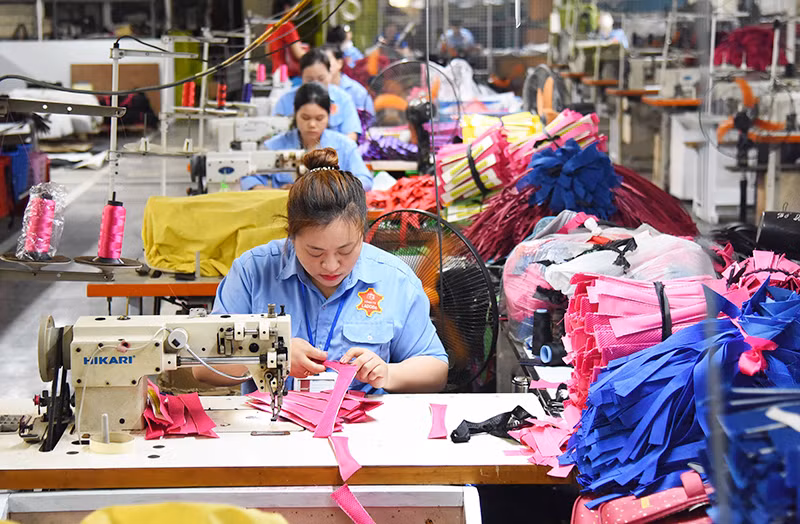 Công nhân Công ty LADODA may túi, cặp da. (Ảnh ĐỨC ANH)