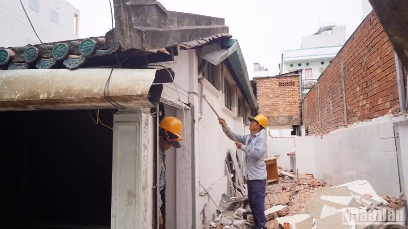 Các công nhân tháo dỡ hạng mục vi phạm xây dựng tại Nhà cổ dân dụng Vương Hồng Sến. (Ảnh: THẾ ANH)